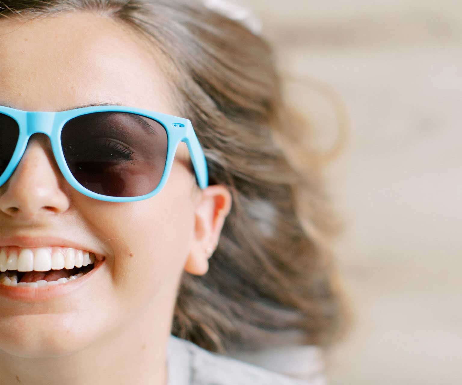 Young girl wearing sunglasses and smiling