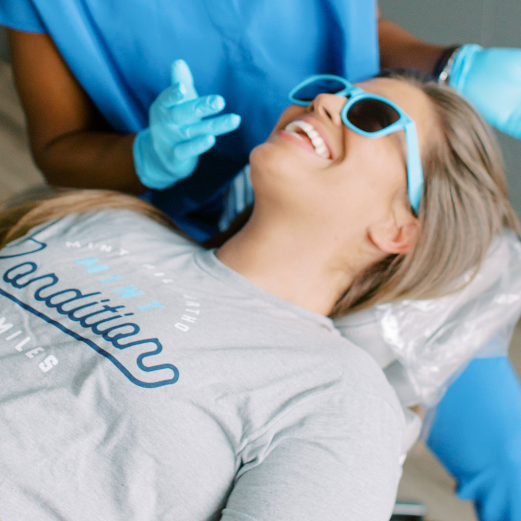 Young girl wearing sunglasses while team member begins examination