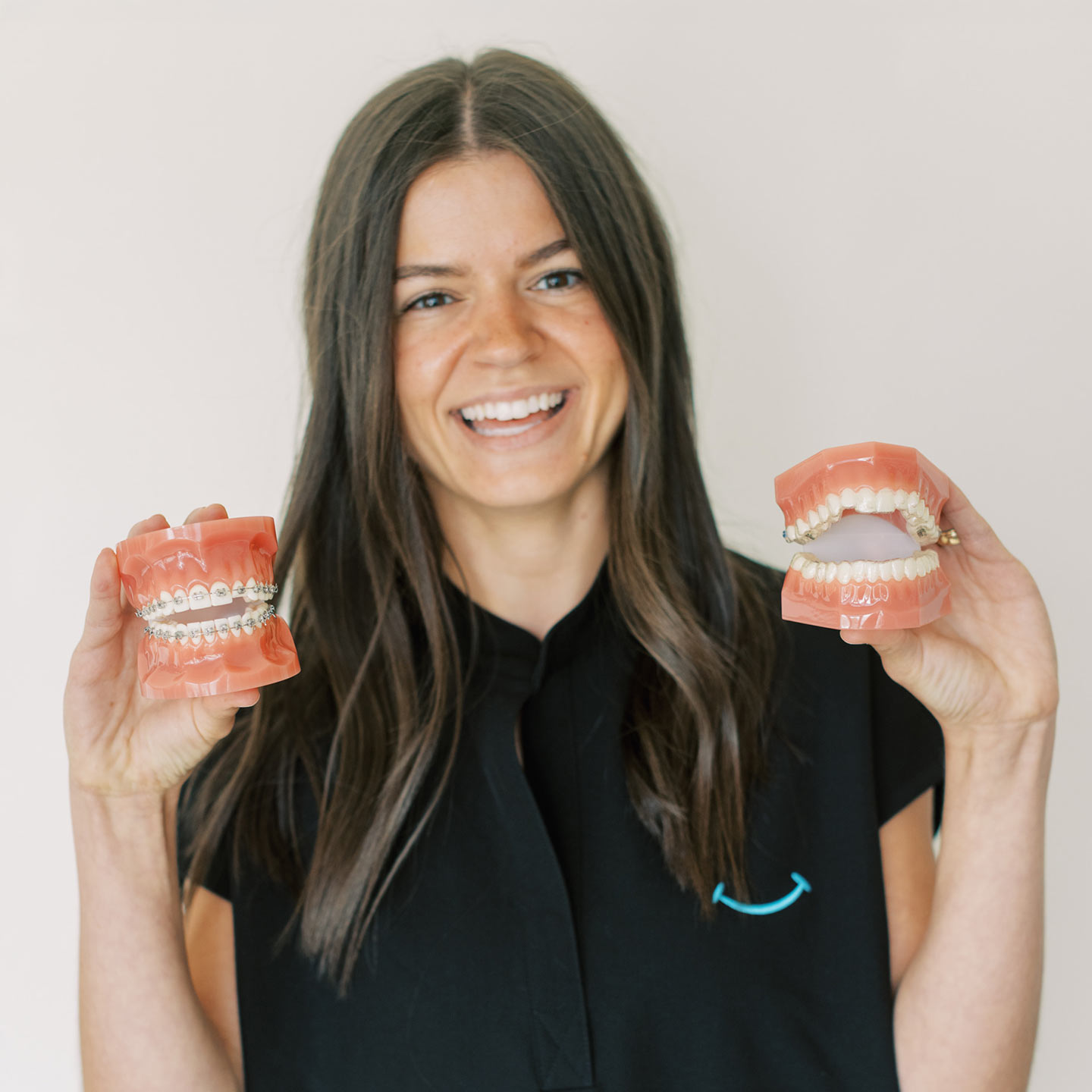 Team member holding up teeth models